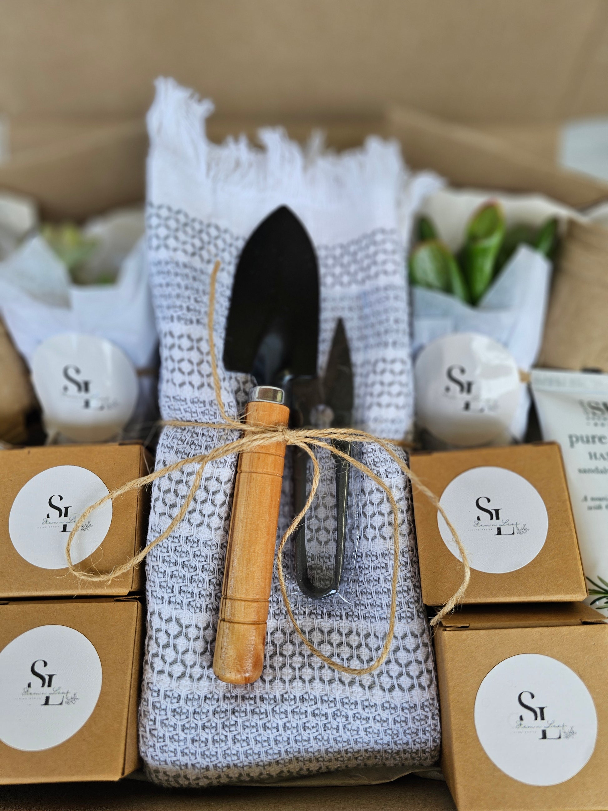 Gardening tools and items in a box with branded labels