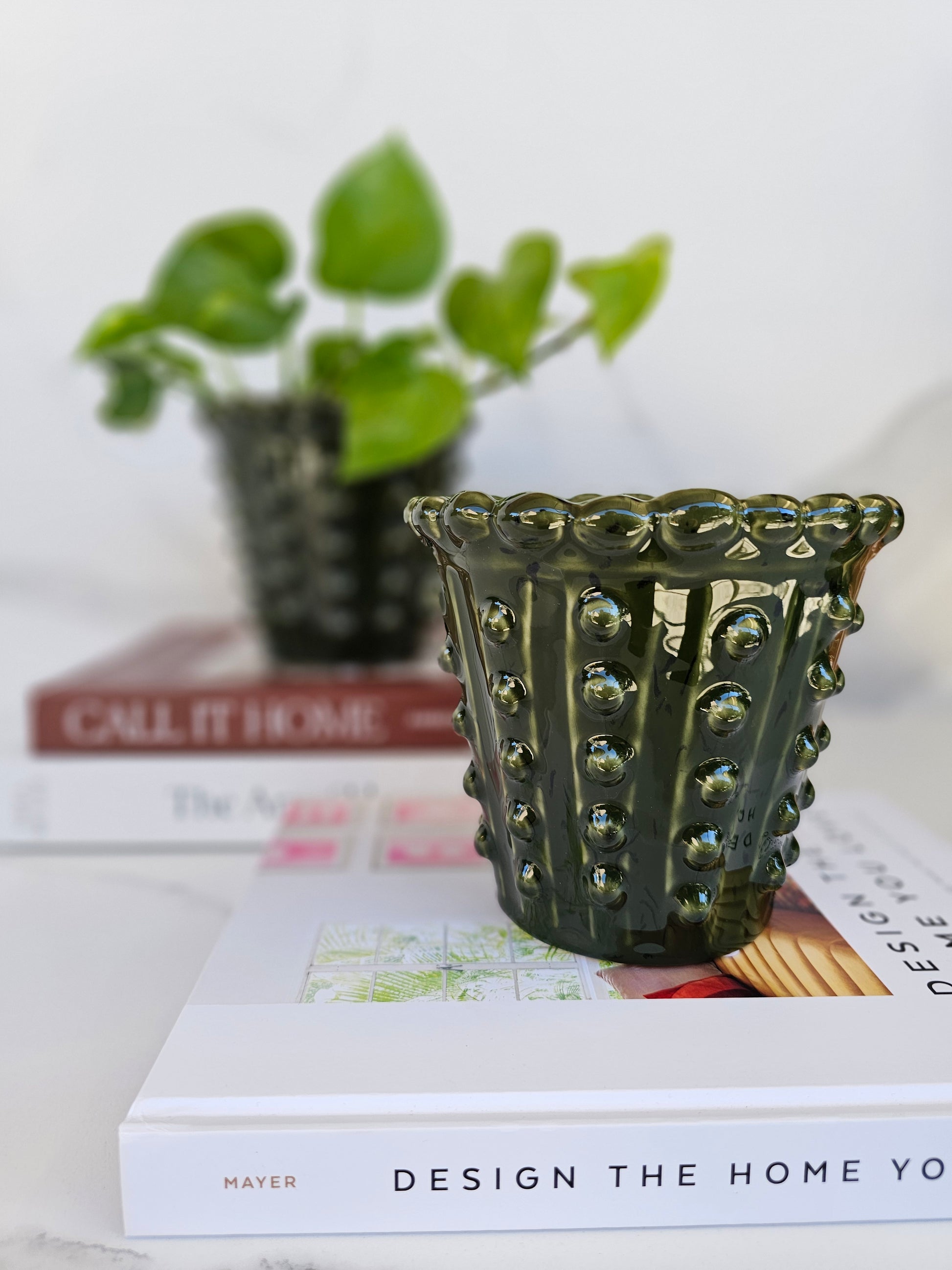 Angled view of a decorative deep green ceramic planter with textured finish.