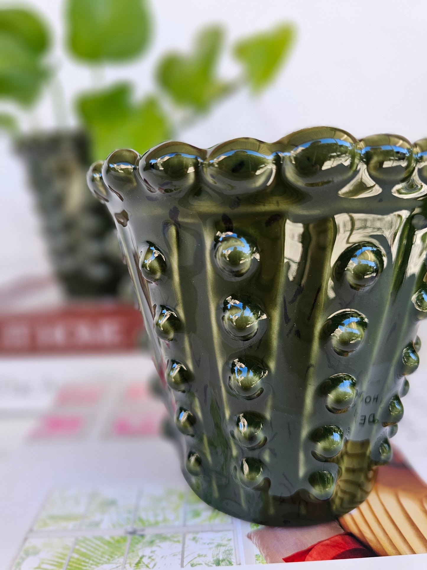 Close-up of the raised hobnail detailing on a deep green ceramic planter.