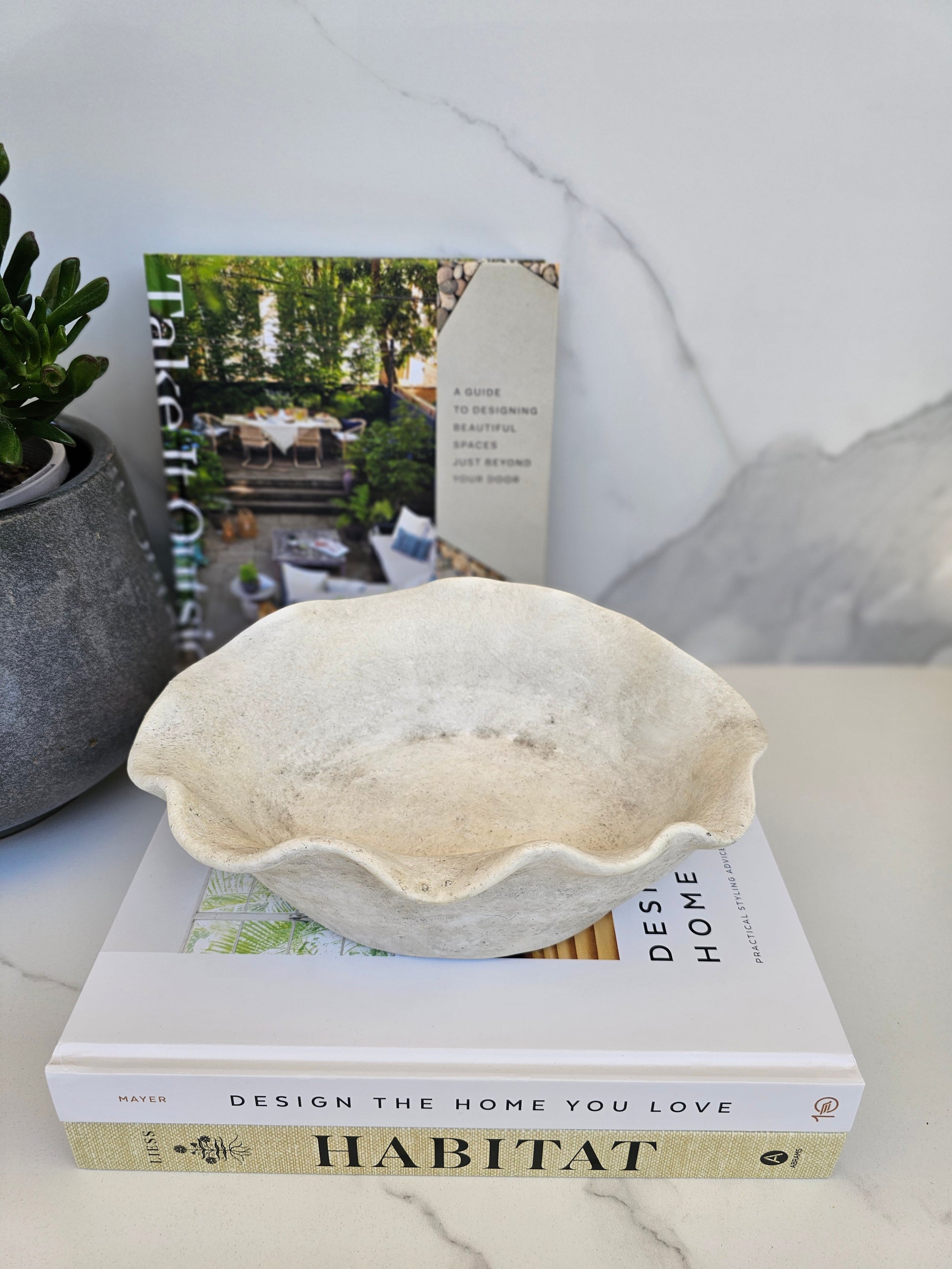 Minimalist stone bowl planter styled with design books for a calm luxury interior aesthetic